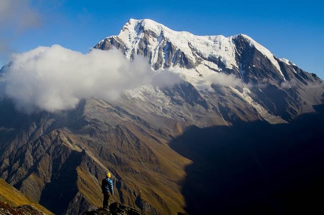 Trekker overlooking snow-covered peaks on the Brahmatal trek